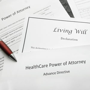 Documents including Power of Attorney, Living Will, and Healthcare Power of Attorney with a pen